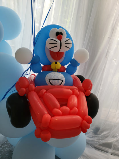 Curtain backdrop with balloon character sculpture and organic garland