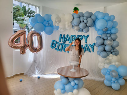 White curtain backdrop with blue balloon garland