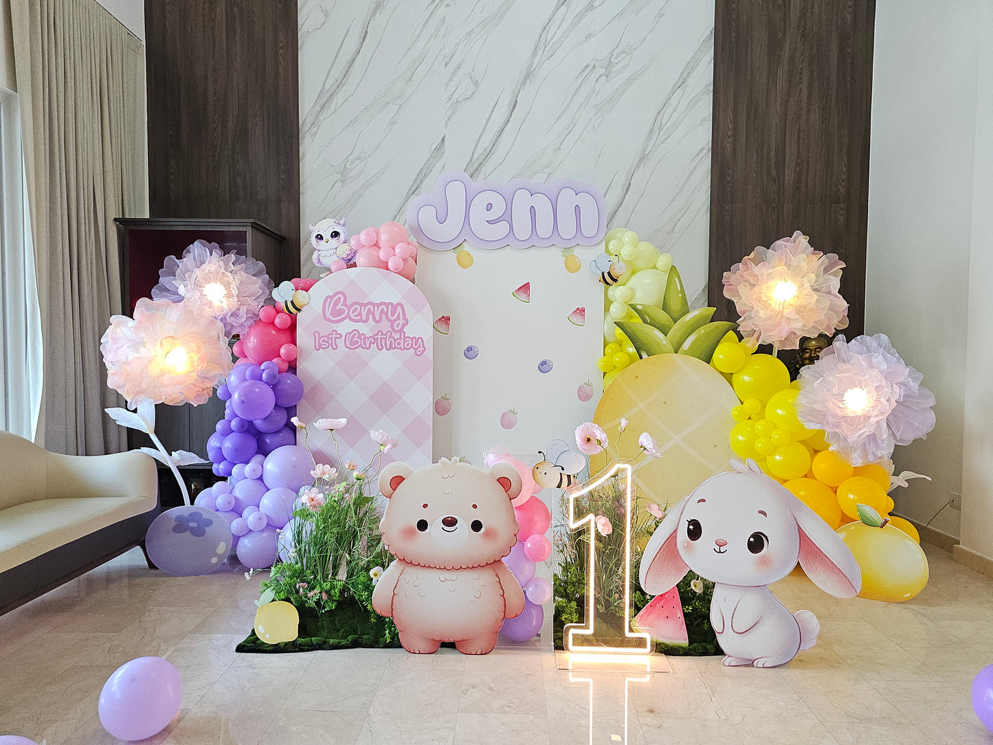 Decorative setup with balloons, teddy bears, and a bunny for a first birthday celebration.