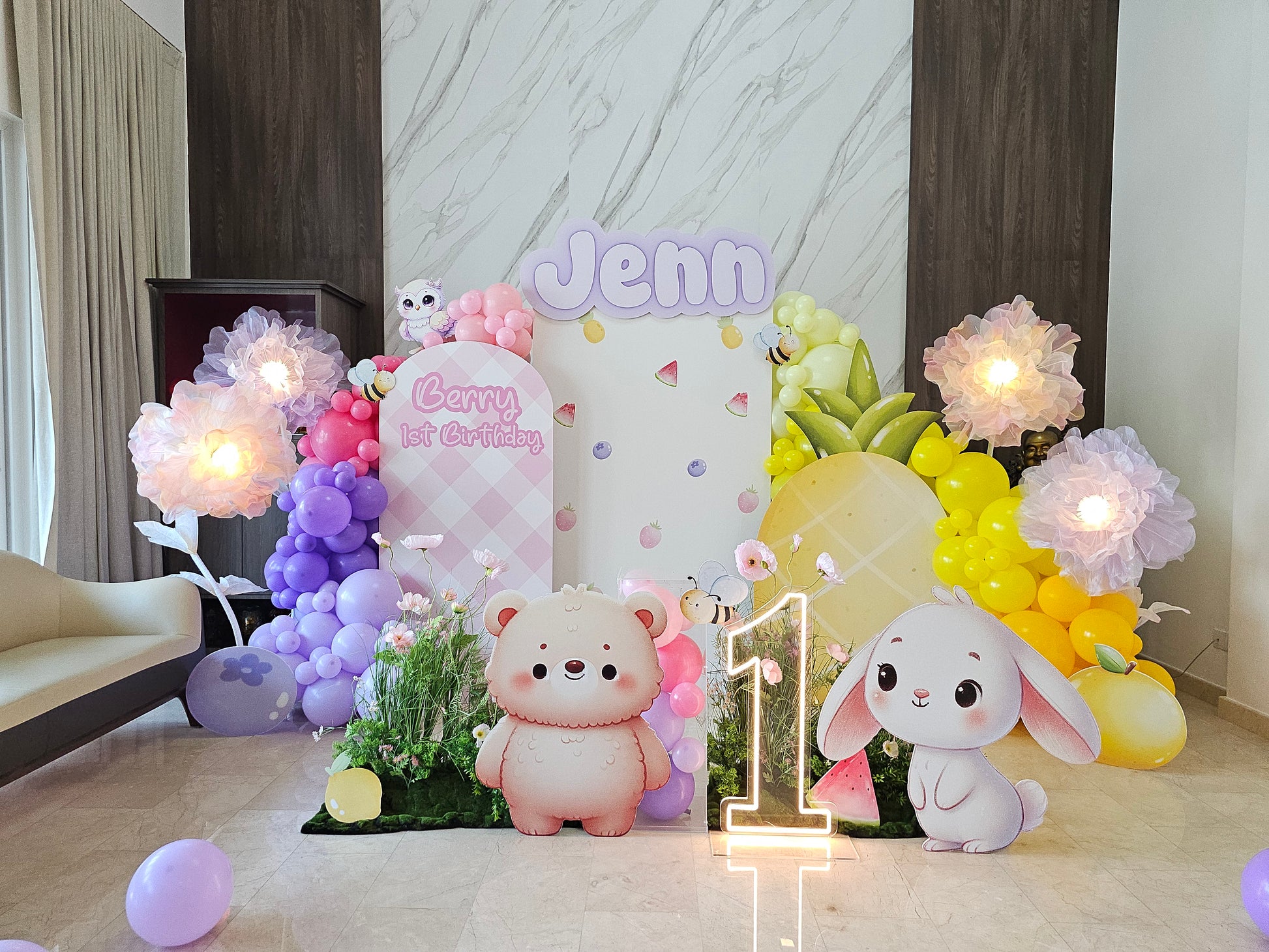 Decorative setup with balloons, teddy bears, and a bunny for a first birthday celebration.