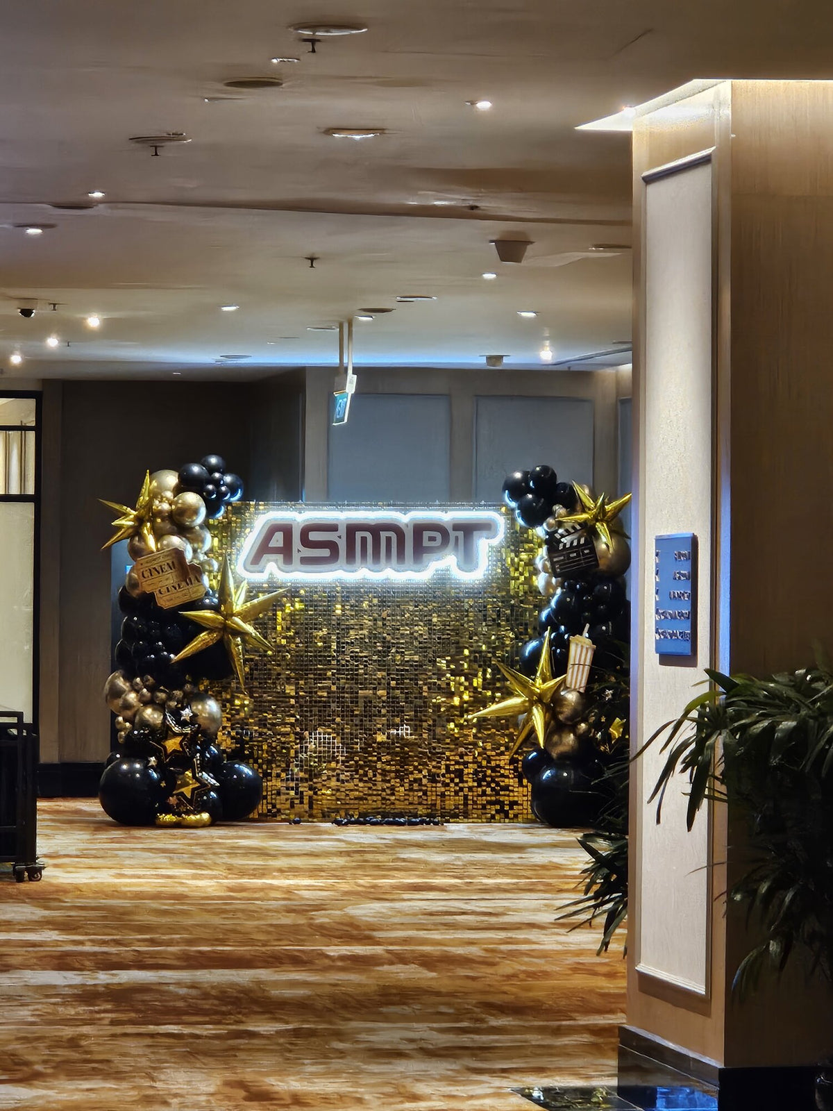 ASMPT corporate event gold shimmer backdrop with organic balloon garland, Singapore