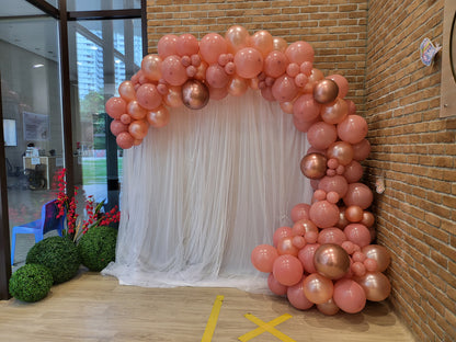White curtain backdrop with organic balloon garland by BalloonClub Singapore